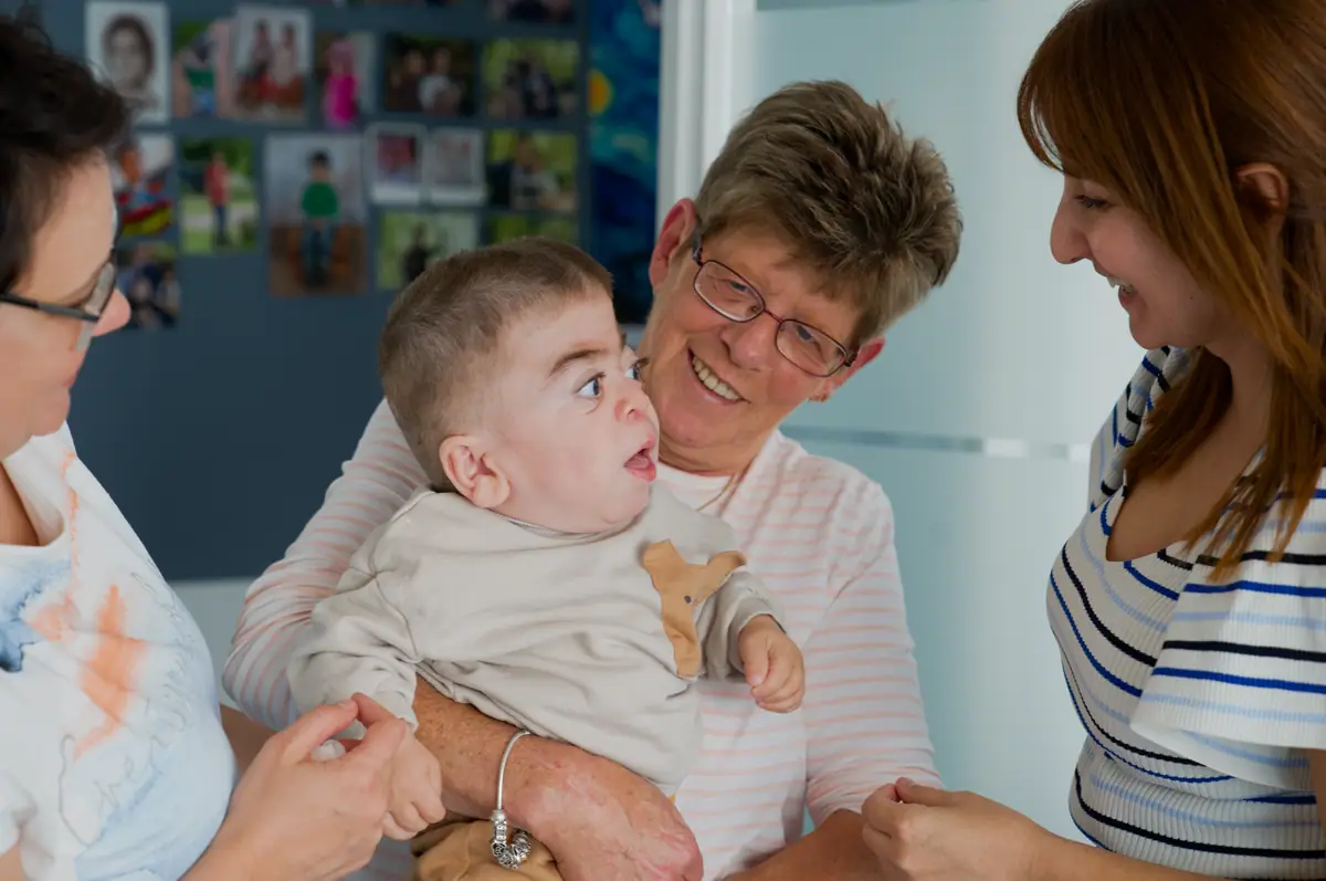 Mutter hält ihr beatmetes Kind liebevoll im Arm